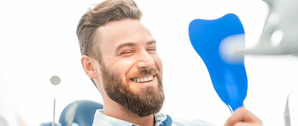 a patient smiling after receiving his dental implants