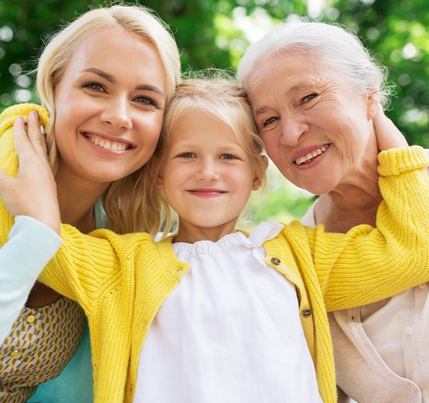 Mother daughter and granddaughter smiling outdoors