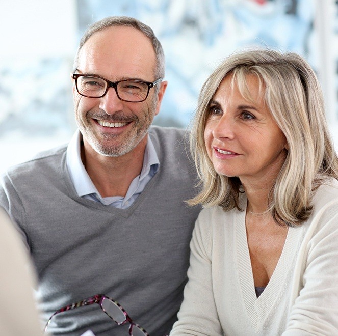 Older man and woman discussing treatment with dentist