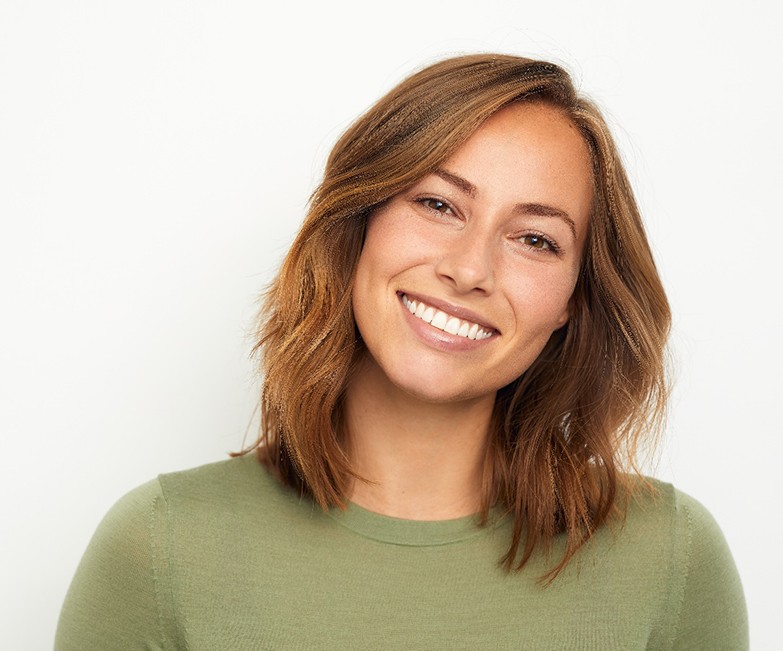 Woman with cosmetic dental bonding in Jacksonville smiling in green shirt