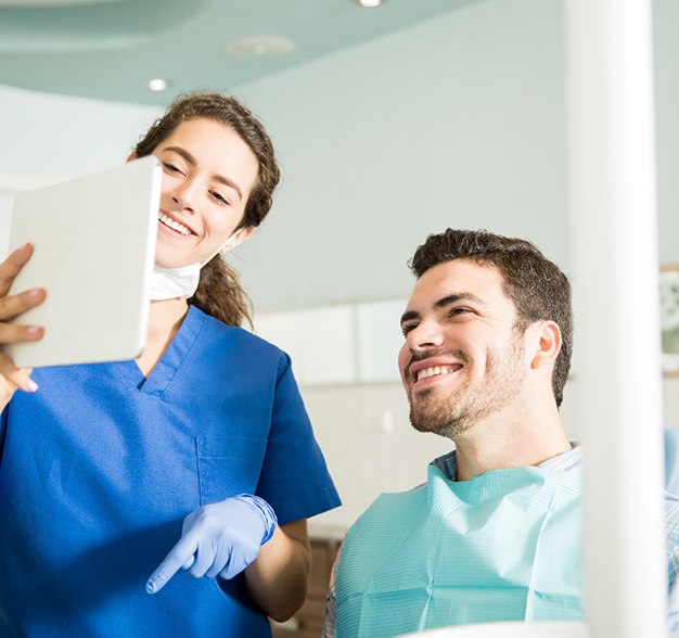 Jacksonville cosmetic dentist explaining treatment process to smiling patient