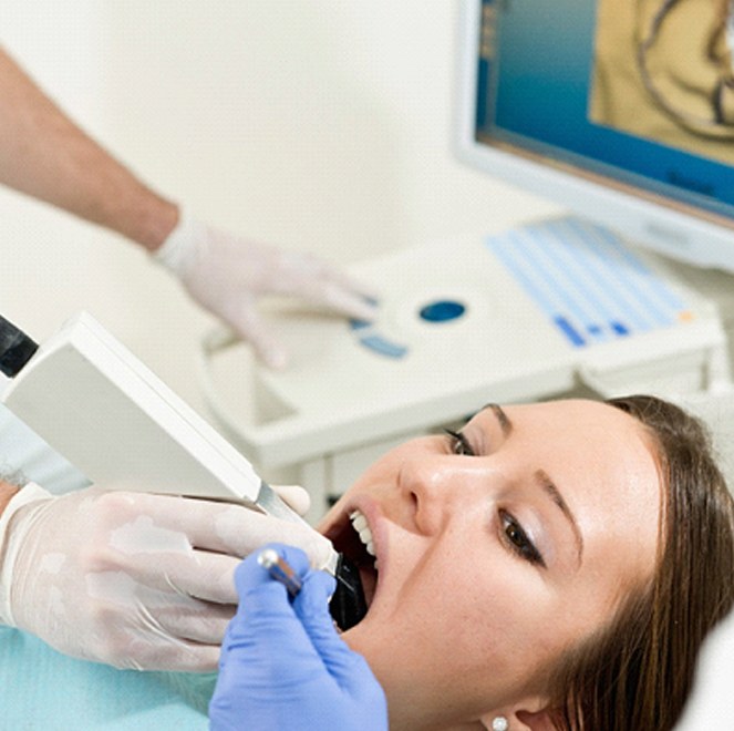 A dentist capturing digital impressions of a patient’s smile in preparation for creating a CEREC crown in Bartram Park