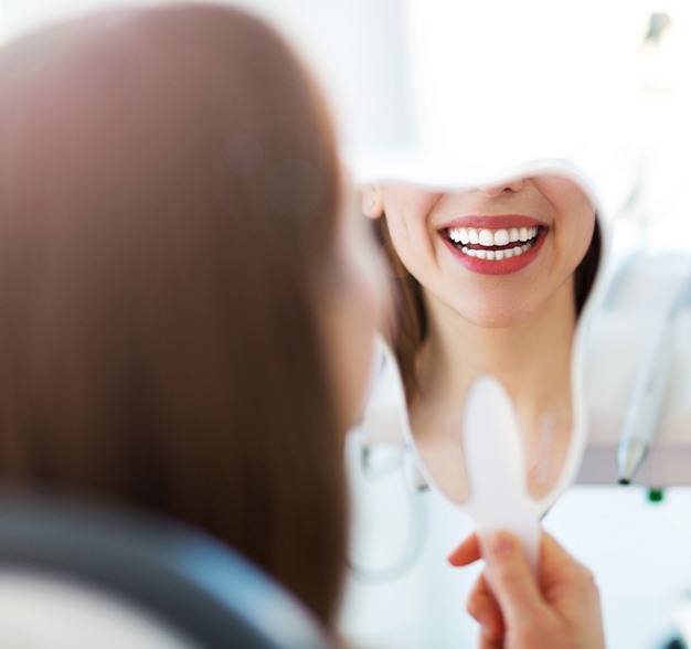 Woman looking at smile after porcelain veneers