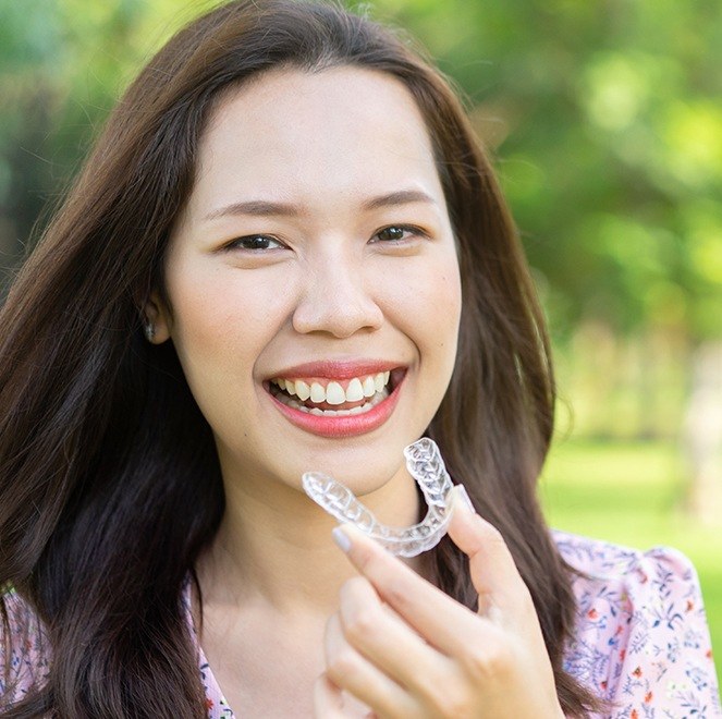 Woman placing Invisalign clear braces alignment tray