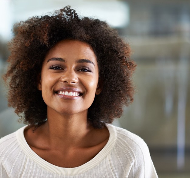 smiling person in an office wearing a white shirt