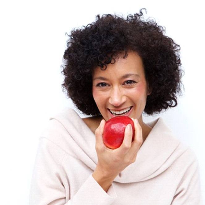 woman biting into a red apple