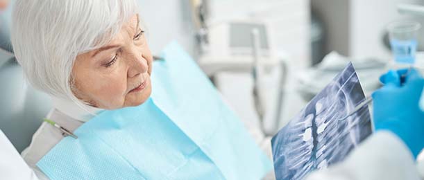 Woman viewing X-ray of dental emergency in Jacksonville with dentist