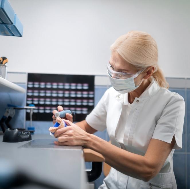 Dental lab technician crafting replacement teeth