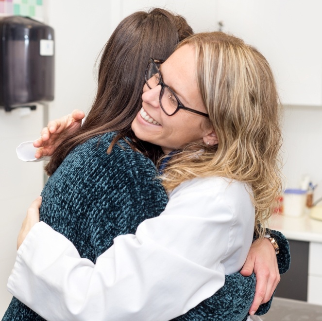 Dental team member hugging dentistry patient