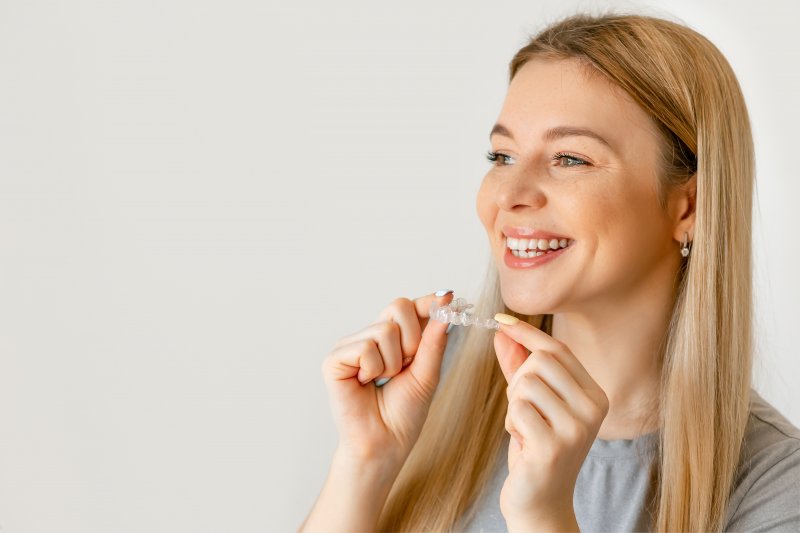 woman smiling with Invisalign tray