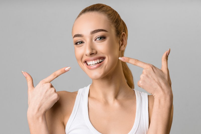 A woman showing her veneered teeth